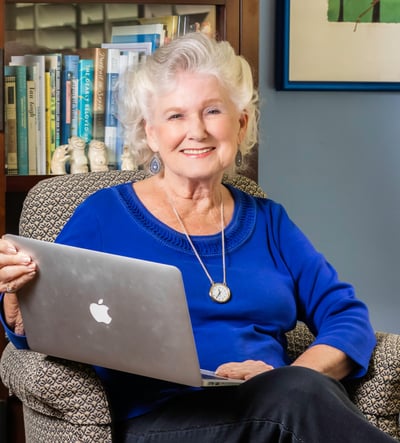 Vivian sitting in chair holding laptop